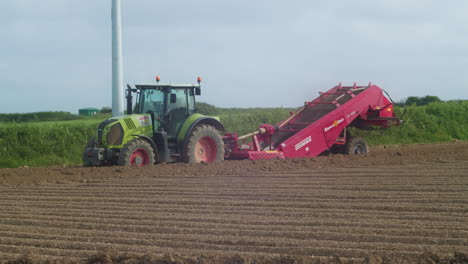 Bauer-Fährt-Mit-Einem-Traktor-Und-Pflügt-An-Einem-Sommertag-In-Cornwall,-England,-Erde-Auf-Einem-Feld---Teleaufnahme