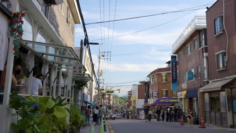 Yongsan-Haebangchon-Dorf-Bei-Sonnenuntergang-Mit-Touristen-Und-Einheimischen-Ausländern,-Die-In-Gemütlichen-Restaurants-Im-Westlichen-Stil-Mit-Veranda-Speisen