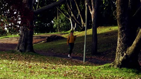 At-dusk,-a-young-woman-is-running-in-a-park