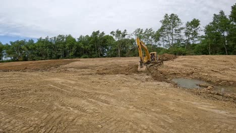 Powerful-hydraulic-excavator-moving-dirt-from-bottom-of-a-slope-to-the-top-of-the-side-bank