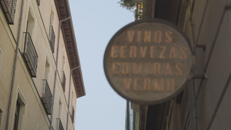 Narrow-street-cafe-sign-hanging-with-majestic-living-apartments-behind