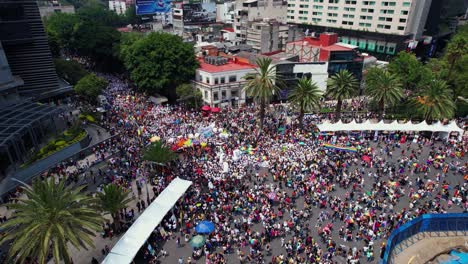 Vista-Aérea-De-Una-Multitud-De-Personas-Multiétnicas-Que-Defienden-El-Orgullo-Gay-En-La-Ciudad-De-México---Reversa,-Inclinación,-Tiro-Con-Drones