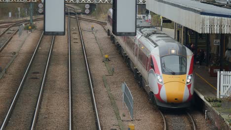 High-Angle-Aufnahmen-Eines-Hitachi-Lner-Azuma-Class-800,-Der-Passagiere-Am-Bahnhof-Von-Lincoln-Abholt,-Während-Ein-Alstrom-Grand-Central-Class-180-Abseits-Der-Kamera-Durchfährt