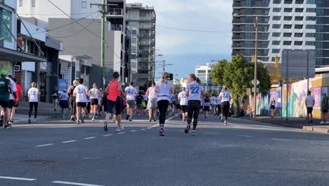 Gruppe-Großzügiger-Teilnehmer,-Die-Für-Die-Spendenaktion-„Bridge-To-Brisbane“-Laufen,-Um-Spenden-Für-Wohltätige-Zwecke-Zu-Sammeln,-Liebe-Und-Unterstützung-Für-Einen-Guten-Zweck-Zu-Zeigen,-Handgehaltene-Bewegungsaufnahme-Auf-Der-Brookes-Street,-Bowen-Hills