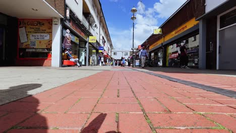 Tiefwinkel-POV-Bodenoberfläche-Des-Stadtzentrums-Von-Crawley-In-Großbritannien-Mit-Menschen,-Die-Durch-Die-Innenstadt-Gehen,-FPV,-Das-Sich-Vorwärts-Bewegt