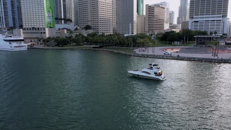 Aerial-view-away-from-a-boat-in-front-of-the-Brickell-skyline,-in-Miami,-USA---pull-back,-drone-shot