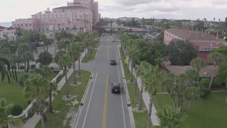 Coches-De-Lujo-En-La-Carretera-Bordeada-De-Palmeras-Cerca-Del-Hotel-Don-Cesar,-St-Pete-Beach,-Florida