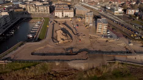 Vista-Aérea-Hacia-Atrás-Que-Revela-Un-Sitio-De-Construcción-Del-Nuevo-Proyecto-De-Construcción-De-Apartamentos-De-Lujo-Kade-Zuid-En-El-Barrio-De-Noorderhaven-En-La-Ciudad-Hanseática-De-Zutphen,-Países-Bajos