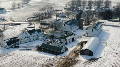 órbita-Aérea,-Nieve-Cayendo-Sobre-Granja,-Granero-Y-Silos-De-Grano