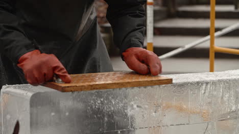 Sartén-A-La-Izquierda-En-El-Artista-Escultor-De-Hielo-Usando-Tabla-De-Clavos-Para-Rasurar-El-Bloque-De-Hielo,-Cámara-Lenta