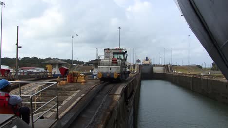 Blick-Auf-Den-Schiffsrumpf-Und-Die-Lokomotive,-Die-Das-Schiff-Langsam-In-Die-Schleusenkammer-Von-Gatun,-Panamakanal,-Zieht