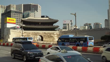 Verkehr-Auf-Der-Straße-Mit-Sungnyemun-Tor-Und-Hochhäusern-Im-Hintergrund-In-Seoul,-Südkorea