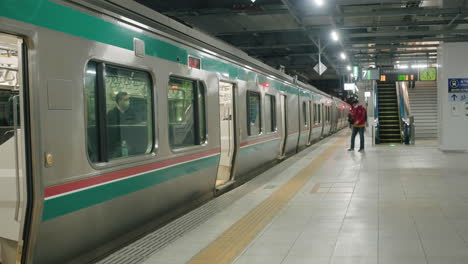 Passengers-Walking-On-Empty-Platform-And-Getting-On-A-Train-At-The-Railway-Station-In-Sendai,-Japan