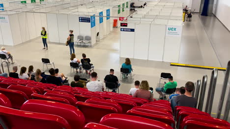 UCK-Gdansk---place-of-universal-vaccination-COVID-19,-people-waiting-on-red-chairs-after-vaccination,-Poland