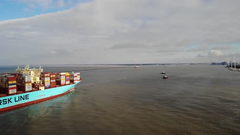 Two-tugboats-waiting-to-assist-maneuvering-the-giant-container-vessel-Marstal-Maersk-into-the-Port-of-Rotterdam-on-a-partly-cloudy-winter-day