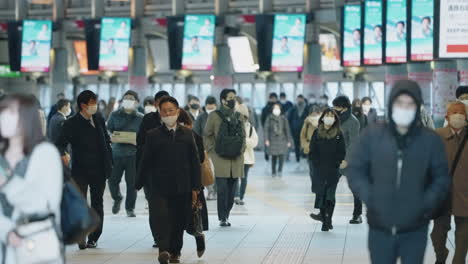 Cámara-Lenta-De-Pasajeros-Con-Máscara-Protectora-Durante-La-Hora-Punta-En-La-Estación-De-Shinagawa-En-Tokio,-Japón,-En-Medio-De-La-Pandemia-Del-Virus-De-La-Corona