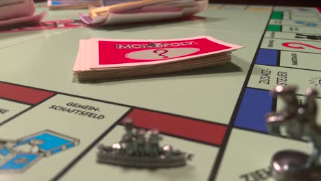 Elige-A-Mano-La-Tarjeta-En-La-Cubierta-Mientras-Juegas-Al-Juego-De-Mesa-Monopoly-En-Casa