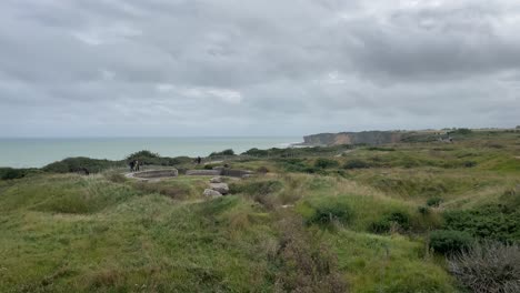 Los-Turistas-Que-Visitan-Los-Búnkeres-En-Las-Playas-Del-Desembarco-De-Normandía-En-Pointe-Du-Hoc