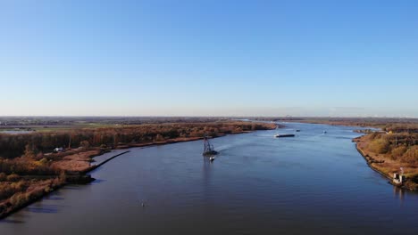 Aerial-Over-Oude-Maas-With-Matador-Floating-Crane-Being-Guided-By-Tug-In-Distance