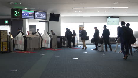 Cola-De-Pasajeros-Que-Abordan-El-Avión-En-La-Puerta-De-Embarque-Del-Aeropuerto-De-Haneda-Durante-La-Pandemia-En-Tokio,-Japón