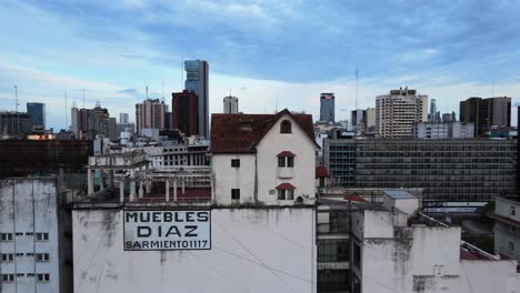 Aerial-pull-out-shot-of-two-story-Norman-style-house,-little-chalet-in-the-sky-perched-on-top-of-a-mixed-residential-and-commercial-building,-affectionately-called-the-chalecito-en-el-cielo