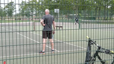 Tenis-De-Práctica-Senior-En-Cámara-Lenta-En-El-Patio-De-Recreo-Público-Suburbano