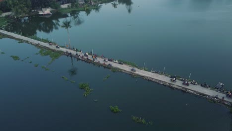 moving-backwards-shot,-the-road-that-divides-a-lake