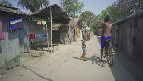 Indian-rural-scene,-two-young-brothers-riding-cycle,-poor-Indian-children