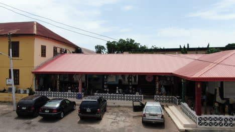 Close-view-of-the-Aafin-Alake-Palace-in-Abeokuta,-Nigeria-and-ascending-aerial-view-of-the-surrounding-suburb