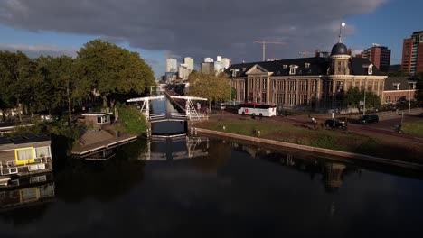 Enfoque-Aéreo-Que-Muestra-El-Museo-Muntgebouw-En-Utrecht-Con-Un-Pequeño-Puente-Blanco-Sobre-El-Canal-En-Frente-En-Un-Día-Soleado-Con-Formación-De-Nubes-En-El-Fondo