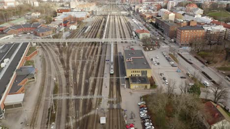 Vista-Aérea-Del-Tren-De-Pasajeros-Que-Llega-A-La-Estación-De-Tren-De-Turku-Durante-La-Hora-Pico,-Pasajeros-Que-Desembarcan