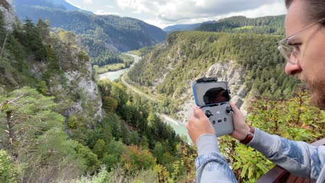 Junger-Hipster-Fliegt-Eine-Drohne-In-Einem-Wunderschönen-Schweizer-Bergtal-Mit-Rhein