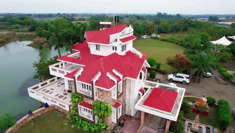 Rotating-aerial-drone-view-of-white-tropical-house-with-a-brick-roof