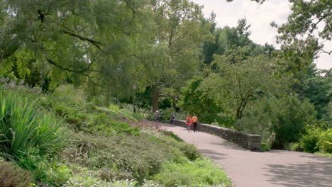 Couple-In-Bright-Colored-Clothes-Walks-In-New-York-City's-Fort-Tryon-Park-On-A-Summer-Day