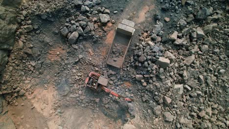 Oben-Rotierende-Drohnenansicht-Des-Baggers,-Der-Erz-In-Einen-Großen-Bergbau-Muldenkipper-Lädt