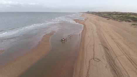 Vista-Aérea-De-Personas-Montando-Caballos-En-La-Playa-En-Katwijk,-Países-Bajos