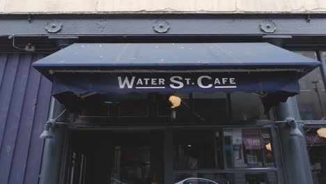 Water-st-cafe-front-entrance-tarp-canopy-medium-wide-angle-panning-down-onto-front-doors-on-sunny-day-downtown-vancouver-BC