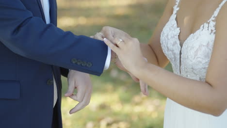 Novia-Arreglando-Pulsera-De-Oro-Alrededor-De-La-Muñeca-Del-Novio-En-La-Ceremonia-De-La-Boda