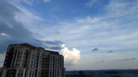 Timelapse-Of-Rolling-Clouds-Going-Over-Residential-Apartment-Tower-Against-Blue-Skies-In-Toronto