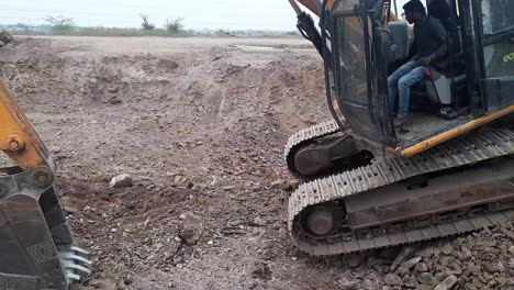 Up-close-view-of-an-excavator-poclain-machine-moving-into-the-ground