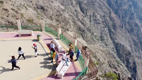 Vista-Aérea-Alrededor-De-Un-Grupo-De-Turistas-En-Un-Mirador-En-La-Parte-Superior-Del-Parque-Forestal-Raghadan,-En-La-Soleada-Arabia-Saudita