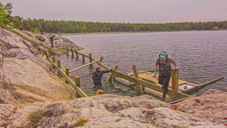 Tiro-De-Lapso-De-Tiempo-De-Los-Trabajadores-Que-Construyen-Un-Embarcadero-De-Madera-Al-Lado-Del-Lago-Azul-En-Un-Día-De-Verano-En-El-Lapso-De-Tiempo