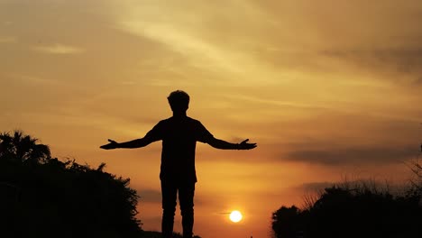 Low-angle-shot-of-man-walking-in-the-street-with-sunset-view-in-the-background-at-Diu-city-of-Inida