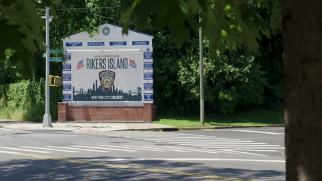 Rikers-Island-Gefängnisschild-In-New-York,-Gesehen-Durch-Die-Blätter-Eines-Baumes