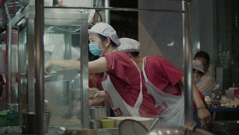 Busy-Street-Food-Vendors-preparing-Noodle-Dish-at-Night,-Bangkok-Street-Food-Noodle-Stall-at-Night