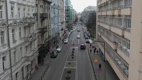 Vista-Aérea-De-La-Gente-Y-El-Tráfico-En-Medio-De-Las-Calles-De-La-Ciudad-Vieja-En-Varsovia,-Polonia---Descendiendo,-Disparo-De-Drones