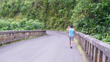 A-back-side-view-of-two-tourist-walking-across-an-empty-bridge-to-explore-the-place