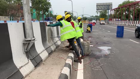 Bauarbeiter-Bohren-Löcher-An-Einem-Straßenteiler-An-Einer-Stark-Befahrenen-Straße-In-Neu-Delhi