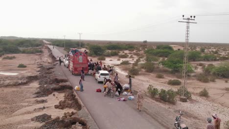 Aerial-View-Of-Locals-Strapping-Food-Supplies-To-Motorbike-In-Remote-Area-In-Balochistan