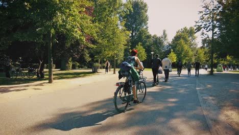 People-Walking,-Biking-And-Riding-Scooters-At-Vondelpark-In-Amsterdam,-Netherlands